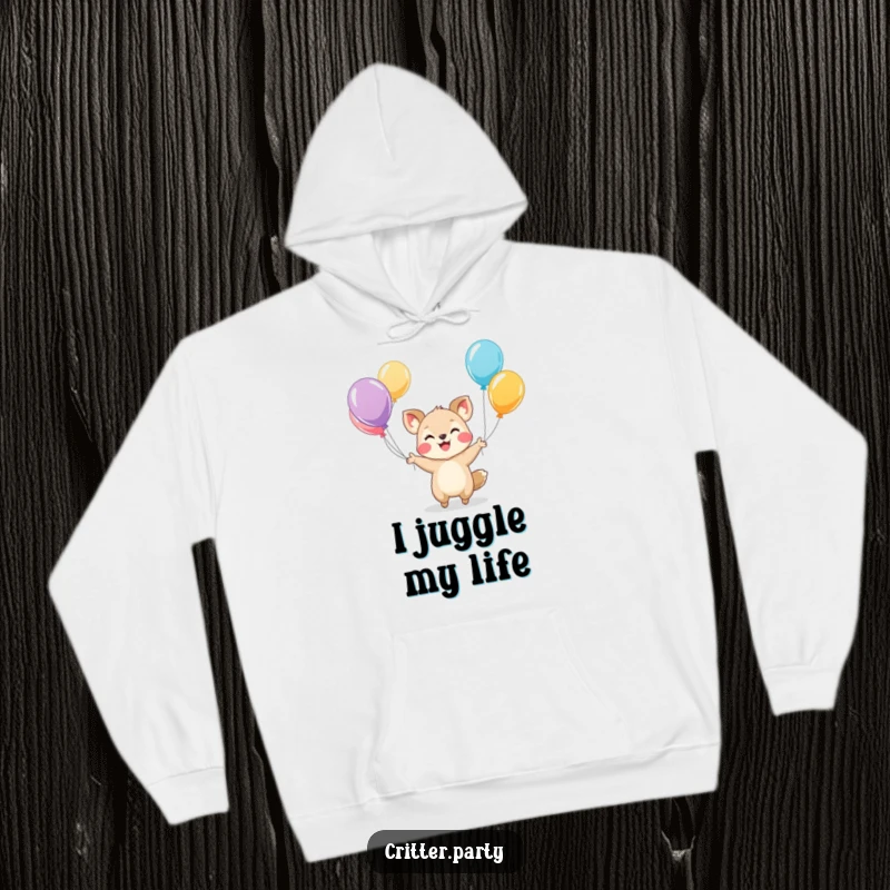 Funny hoodie featuring a small, smiling animal character skillfully juggling a cluster of bright, colorful balloons, embodying playful energy.