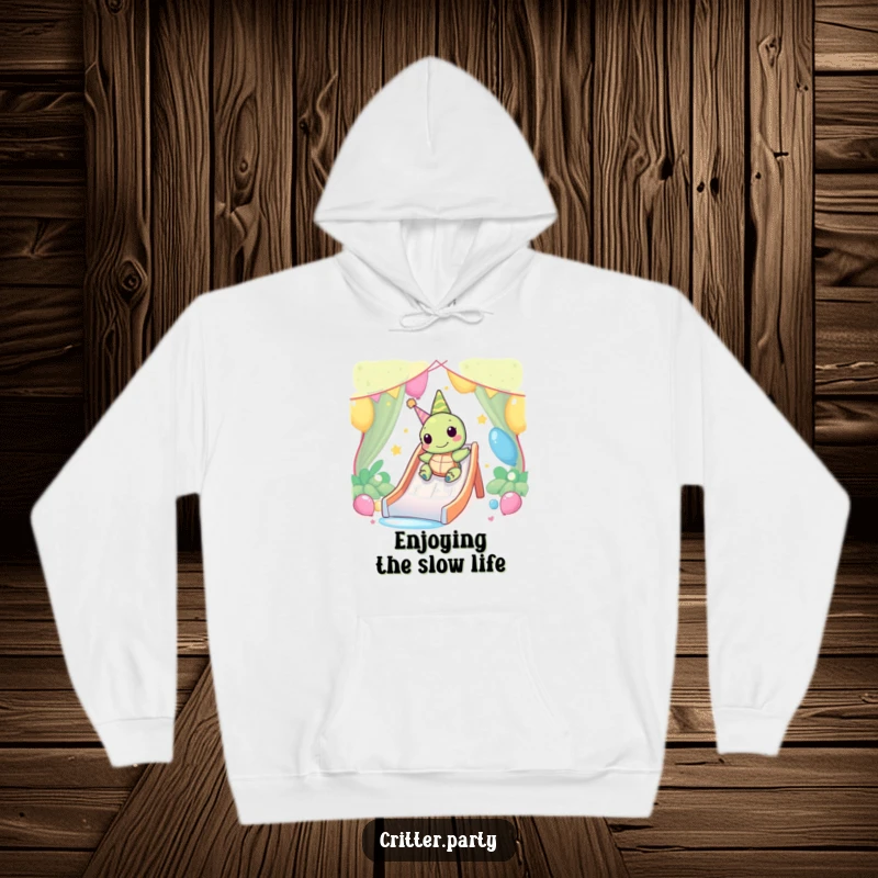 Funny Kawaii turtle character slowly and happily sliding down a party slide, printed on a cozy hoodie.