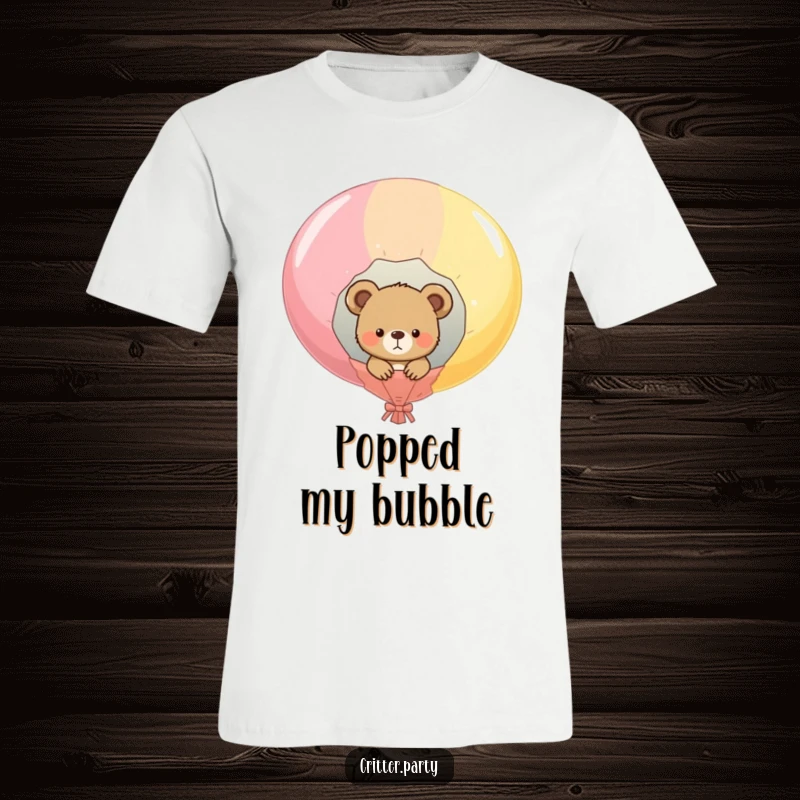 Funny t-shirt with curious bear cub peeking out of a giant popped balloon, cartoon style, conveying playful surprise and humor.